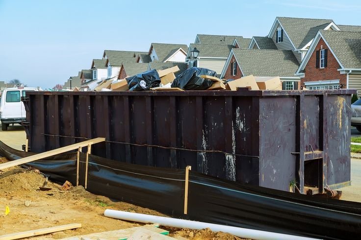 dumpsters being full with garbage in a city.